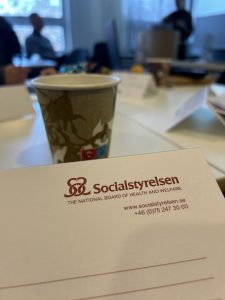 En kaffekopp, ett papper med Socialstyrelsens logga